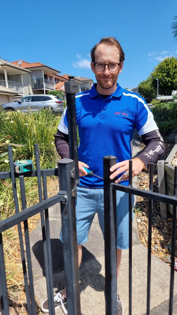 Photo of the pool safety inspector John-Claude Vermaak standing behind a pool gate